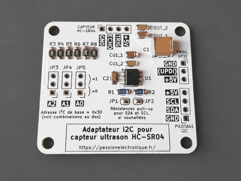 Photo de composants électroniques CMS soudés sur un circuit imprimé blanc, avec sérigraphie noire sur white PCB, projet d'apprentissage de l'électronique simplement